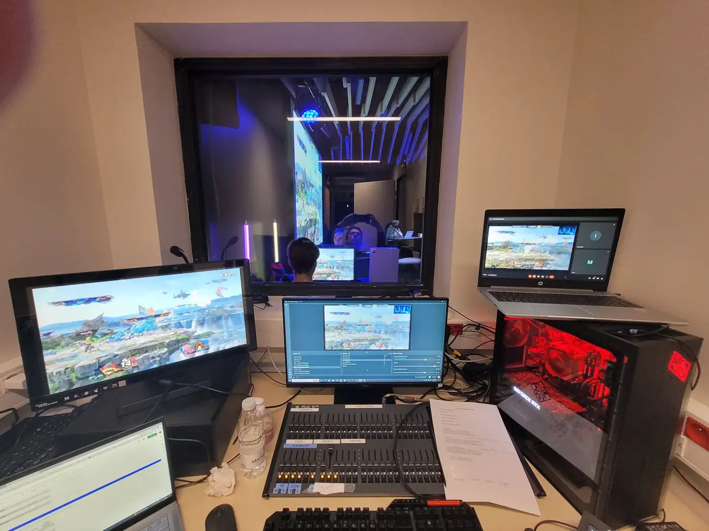Régie lumière et diffusion du tournoi A-Games : table de mixage, écrans de contrôle et poste de streaming