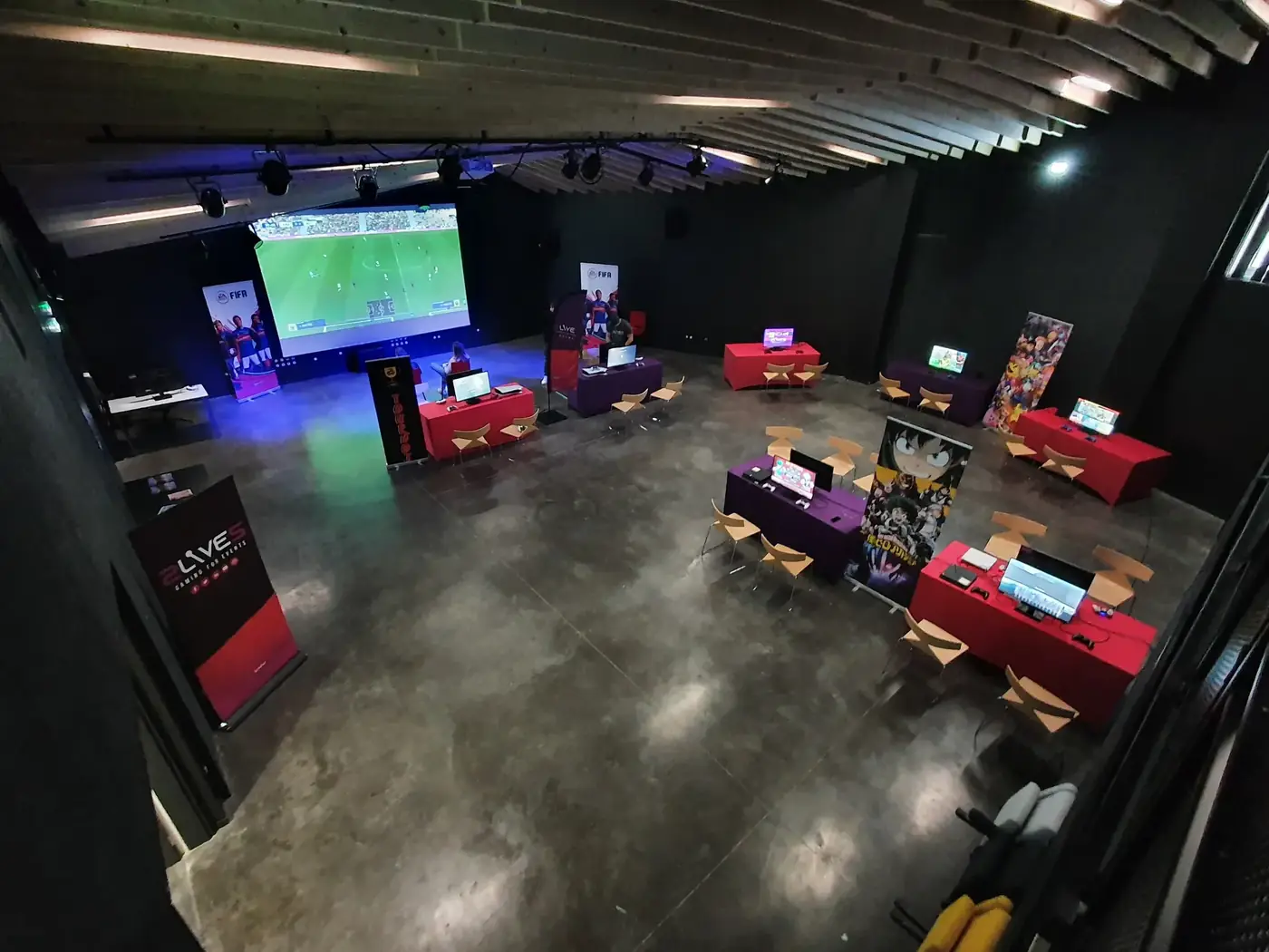 Salle de tournoi e-sport aménagée avant l'ouverture au public, postes de jeu et écran géant